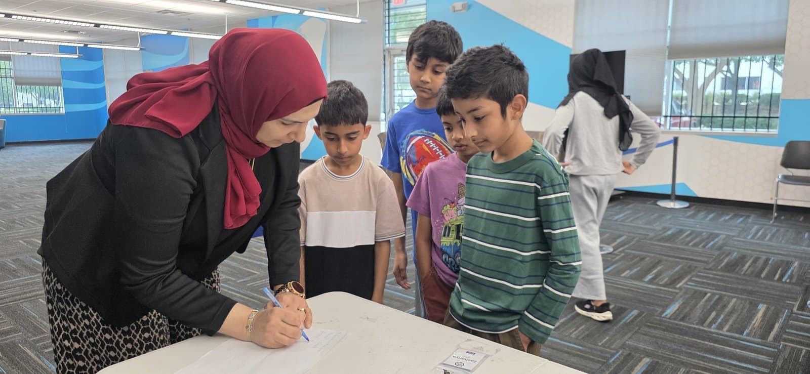 A coach helps students get oriented as the first FLL session begins at the ITKAN Innovation Hub