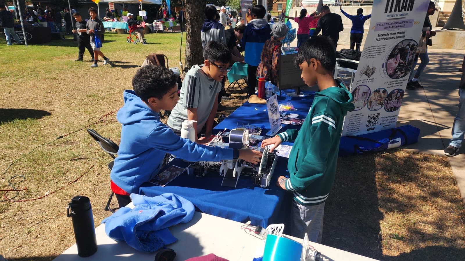 Children try a robot at the ITKAN table at the Plano International Festival