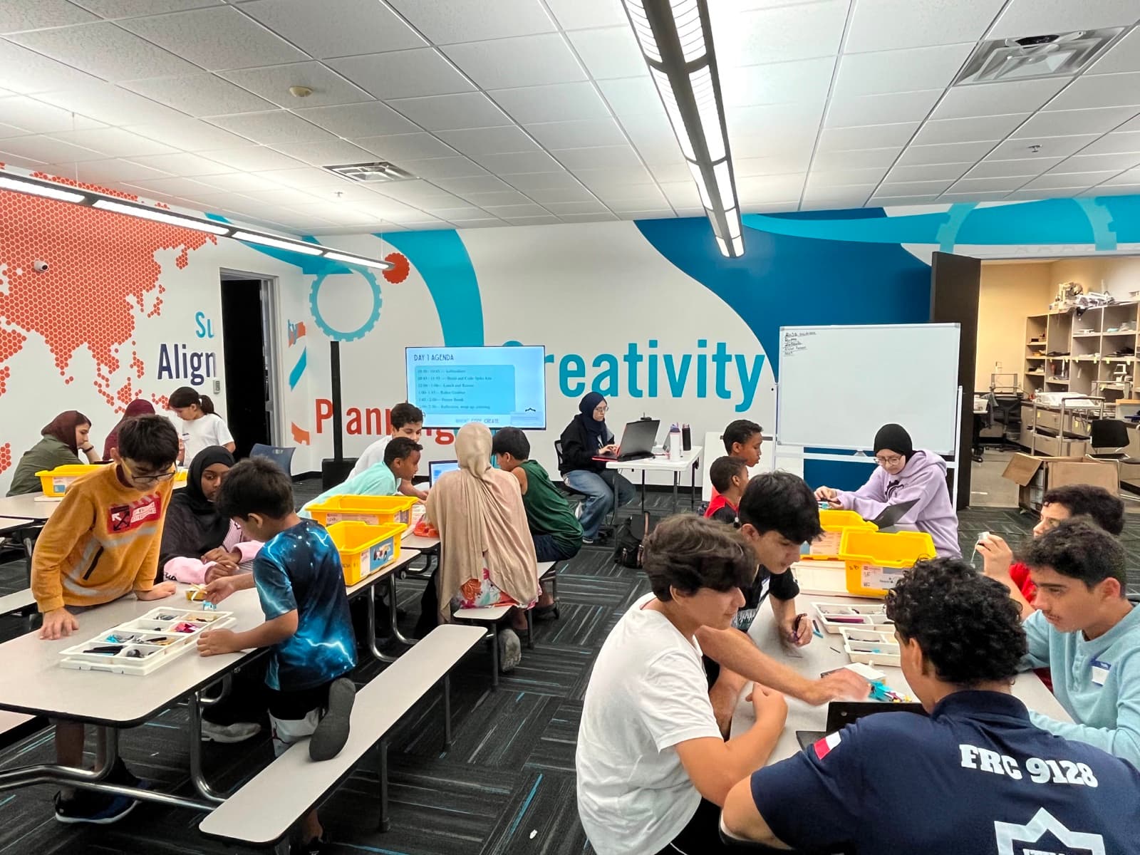 Ma'ruf community students work with robotics kits at tables in the ITKAN Innovation Hub STEM classroom