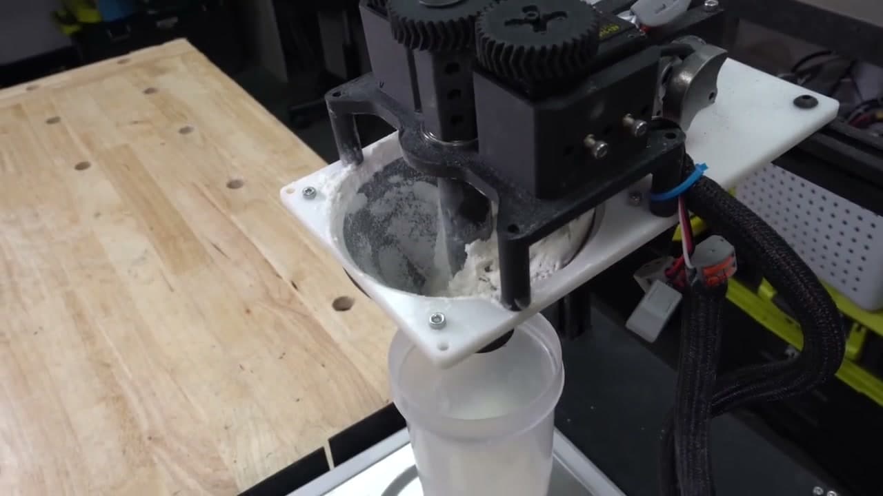 A team's 3D printed auger dosing head dispensing powder into a funnel