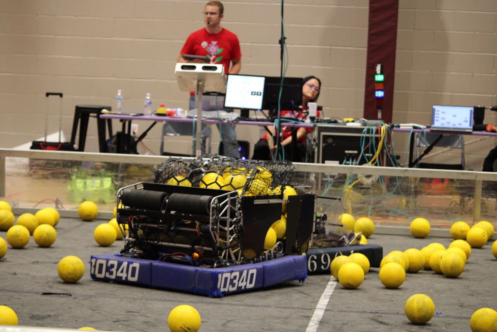 The 10340 robot in blue bumpers, its basket full of yellow game pieces, beside alliance partner 6901