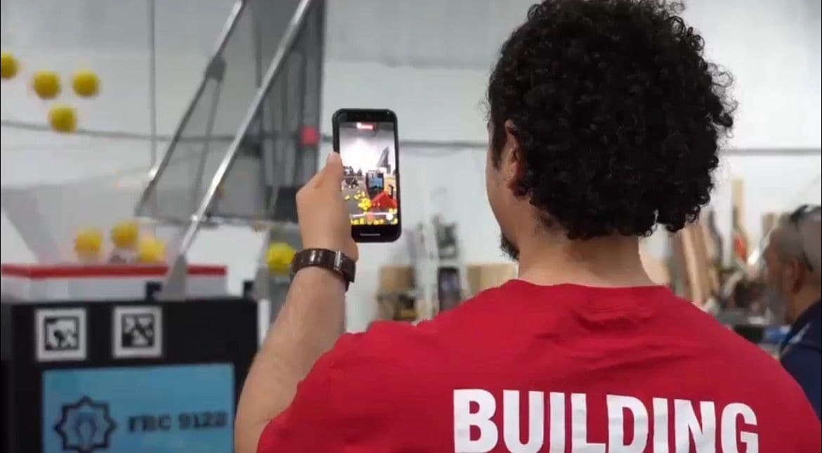 ITKAN students lead a robot demonstration under a “Building stronger communities” banner